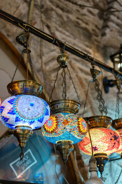 Colorful mosaic lamp chandeliers hanging in a bazaar market in Izmir, Turkey, attracting shoppers and visitors