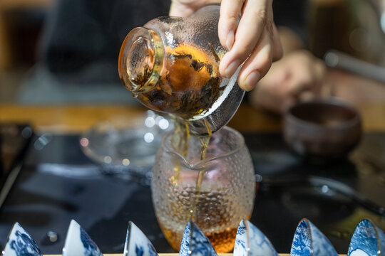 Tea is poured into a glass during a traditional tea ceremony in Sichuan, China, showcasing the process and utensils used