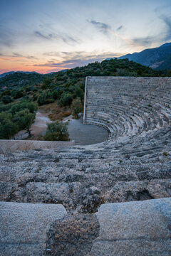Sunset view of ancient theater in Antiphellos with stone seating and surrounding landscape in Kas, Turkey