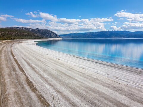 Salda lake view from above shows white sand and blue water under a clear sky in Turkey during a sunny day