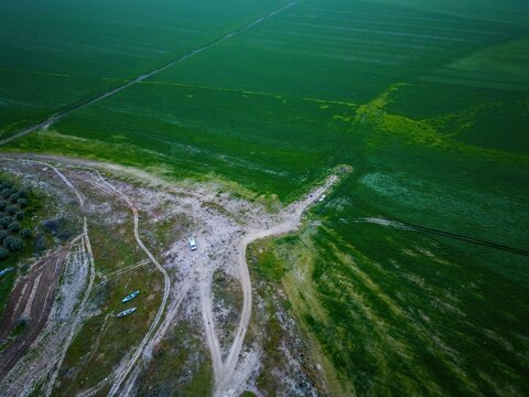 Camper van in green landscape of Marmara dry lake during sunset in Turkey with fields and pathways visible in the background