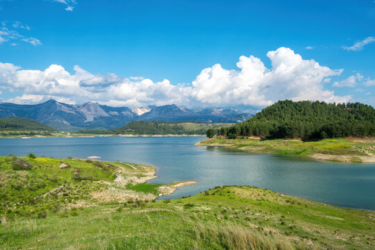 Karacaoren dam lake with turquoise water surrounded by trees and mountains under clear blue sky in Turkey
