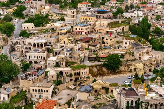 View of traditional houses in Ortahisar city from the castle in Cappadocia, Turkey with a hint of the surrounding green landscape