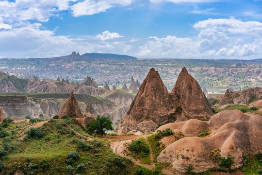 Colorful rock formations and valleys view with Ortahisar city in the background in Cappadocia, Turkey during daylight hours