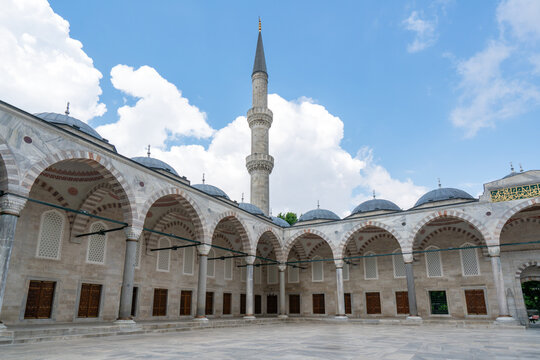 Visit to the Blue Mosque featuring a tall minaret in the heart of Istanbul with people exploring the courtyard