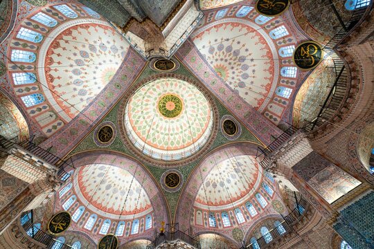 View of the intricate ceiling design inside Yeni Mosque located in Istanbul, Turkey showcasing ornate patterns and colors