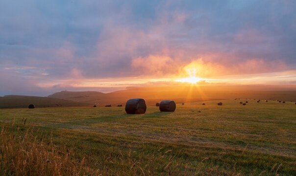 Sunset over hay bales in South Downs National Park near Beachy Head, East Sussex, England