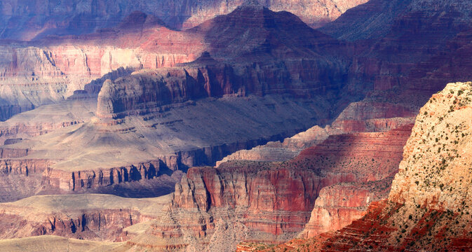 View of Grand Canyon from the South Rim showing rock formations and shadows in the landscape during daytime