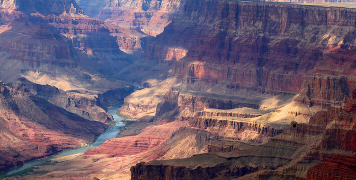 View of Grand Canyon with Colorado River flowing through deep canyon in Arizona USA during daylight hours in summer