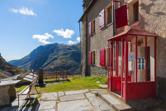 Pian del Re Mountain Refuge offers a view of mountains during summer in Cuneo, Piedmont, Italy, Europe with bright sky and green grass