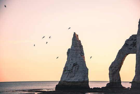 Fly past Needle Aiguille dEtretat and Arch Rock Falaise dAval formations at sunrise in Normandy