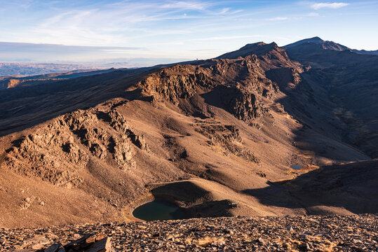 Sunrise over high alpine tarn in Sierra Nevada National Park with Cerro del Caballo in background
