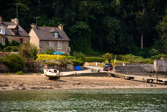 Granite cottages and slipway at a hamlet on the Rance estuary in Brittany France during daylight