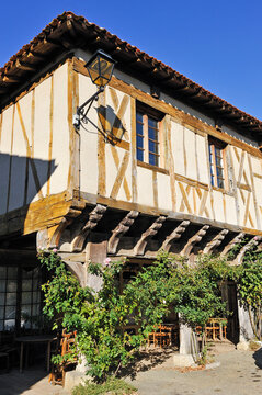 Timber framed house with wooden supports and greenery in southwest France