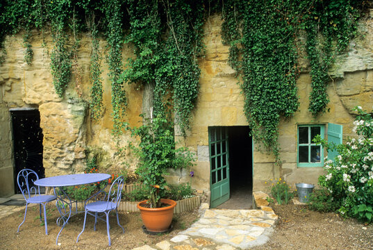 Troglodyte holiday cottage with outdoor seating and greenery in France
