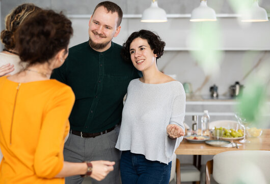 Married couple sees off guests after house party, says goodbye to friends. Party visitors leave hospitable house, take depart event