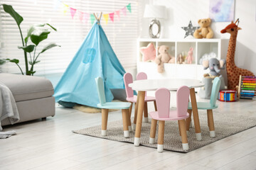 Child's room with furniture, toy wigwam, toys and colorful flags. Interior design © New Africa
