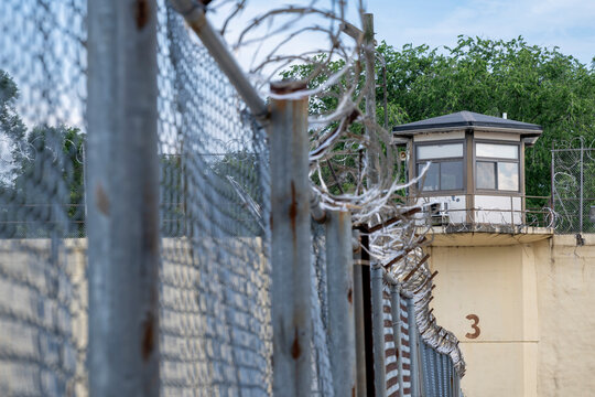 Prison guard tower with razor wire fence.