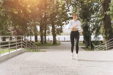 Fototapeta premium Woman running outdoors in park, practicing fitness and healthy lifestyle during a sunny day exercise