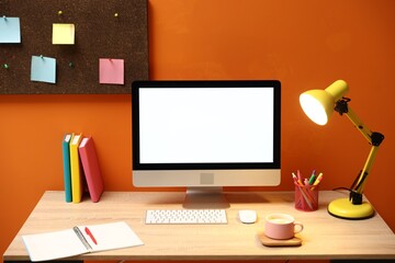 Naklejka premium Stylish workplace with modern computer, lamp and stationery on wooden table indoors