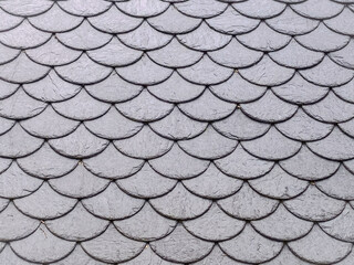 Grey slate roof tiles pattern - Fish scale shingles texture background © JR Foto