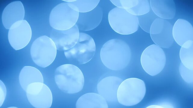 Soft focus image of glowing, circular light forms against a gradient blue background, creating a dreamy, abstract effect