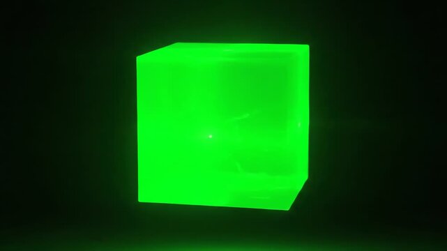 A glowing rectangular object in a dark setting, illuminated with vibrant green light, creating a strong contrast