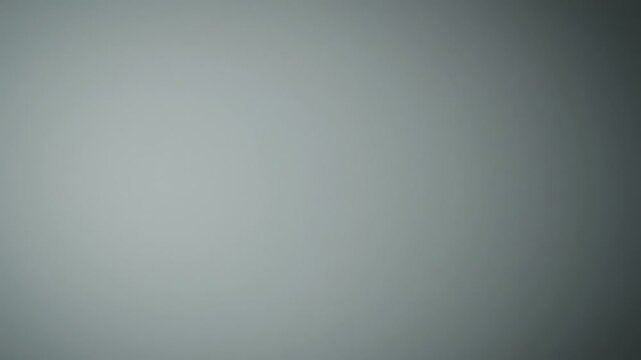 A gradient background with shades of gray and a soft blur effect. The image features a smooth transition between darker and lighter tones