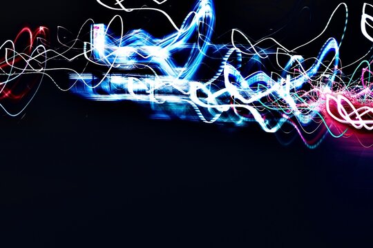 Neon light trails with copy space on dark background for modern design
