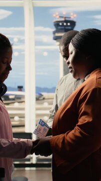 Vertical Video Supportive parents and teenage child in sad goodbye at the airport terminal, the pain and pride of sending young solo traveler to study abroad. International student life, departure