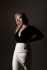 Naklejka premium Portrait of a woman in stylish outfit with dark background capturing elegance and confidence in studio lighting