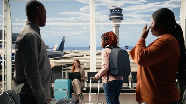 Foreign student, waving goodbye to tearful parents, emotional moment in airport, solo traveler leaving sad but proud mother and father to study abroad. International flight departure.