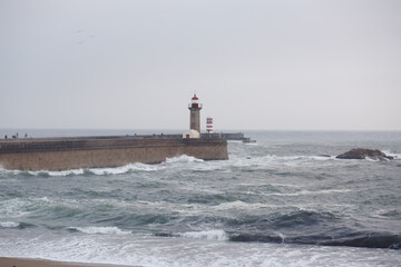 Obraz premium Lighthouse on the Atlantic Ocean with waves in Porto, Portugal