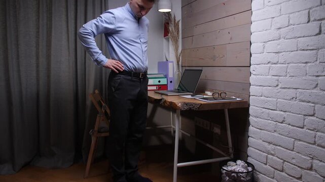 Overweight man standing in his home office, looking at his increasing stomach size, symbolizing the health challenges and sedentary lifestyle often associated with remote work