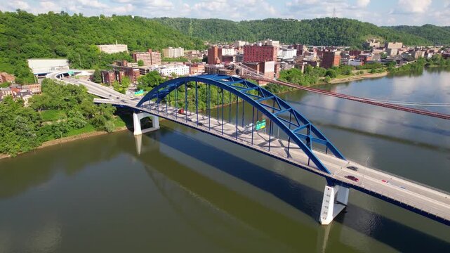 WEST VIRGINIA - 6.24.2024 - Very good aerial footage panning traffic driving across bridges on the Monongahela River in West Virginia.