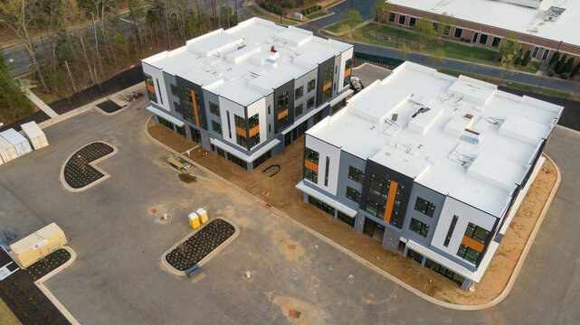 Aerial drone inspection of commercial TPO roof featuring heat-welded seams, HVAC curb flashing, and pipe penetrations.