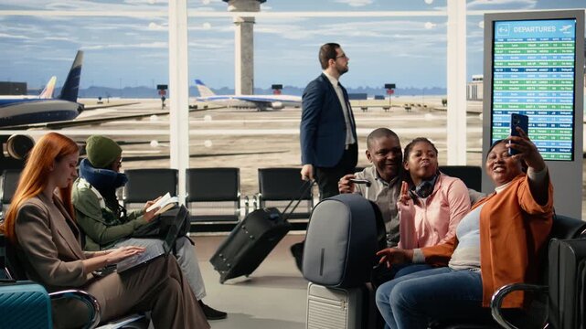 Family of three taking pictures on phone in bright airport waiting area, parents and teenage daughter on a bench with plane ticket and travel documents ready. Boarding flight in cheerful good mood.