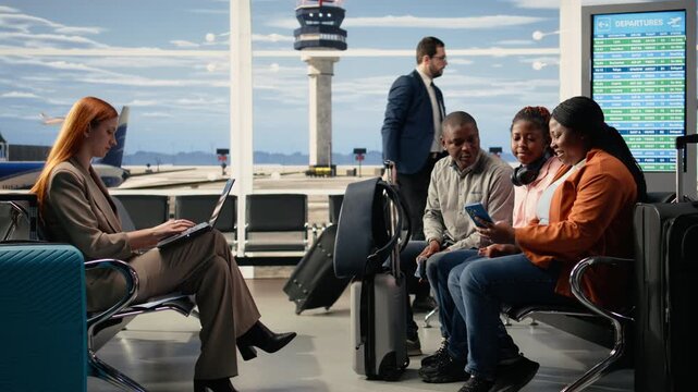 African American family taking photos before boarding plane at busy airport lounge, parents and teenager relaxing in waiting area before departure with luggage near gate. International vacation.