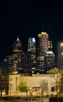 View of the Downtown Atlanta Skyline Cityscape showing several prominent buildings, highways, cars, and hotels on a beautiful clear night.