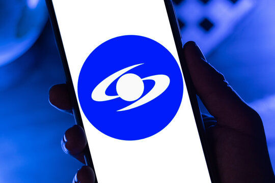 Close-up of a hand holding a phone with the Caracol Televisi&oacute;n logo on the screen, representing journalistic investigation, social debate, and virality on digital platforms