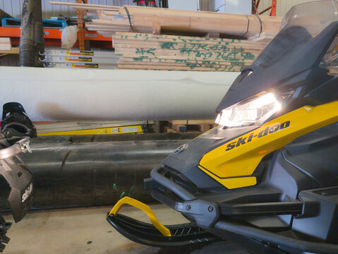 Quebec, CANADA, 23 February 2026 : Snowmobile in Workshop with Lumber and Tools