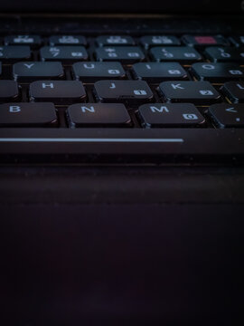 Macro high-angle view of a black laptop keyboard with white lettering and low-profile chiclet keys in soft indoor lighting