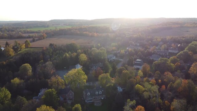 Aerial view of the Cheltenham area, a community within the town of Caledon, Ontario, Canada. Shot by a drone on an autumn afternoon, flying west towards the sun.