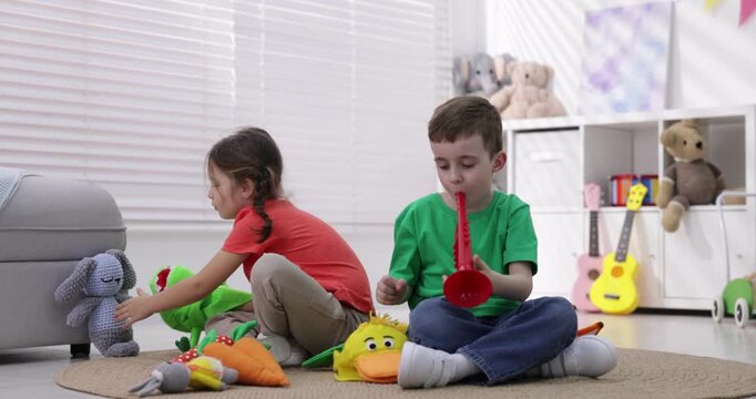 Cute little kids playing with toys on floor indoors