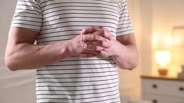 Man interlaced his fingers at home, closeup