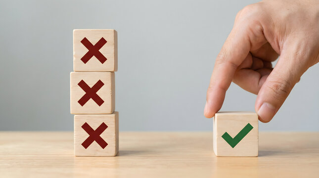 Hand placing a checkmark cube next to three cross cubes, decision making concept