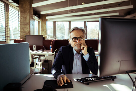 Senior businessman working at desktop computer in modern office
