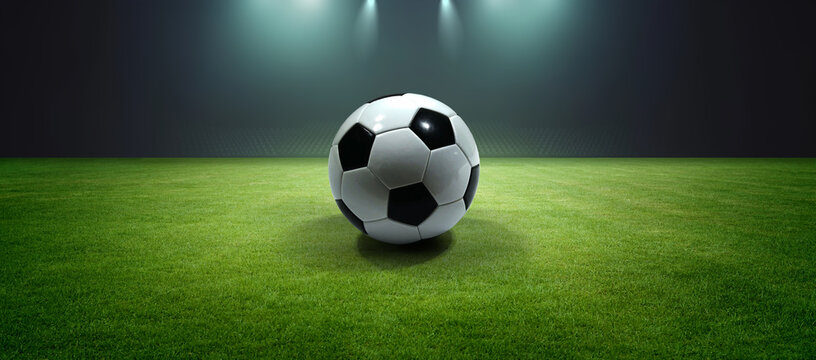 Ball on the pitch under dramatic stadium lighting