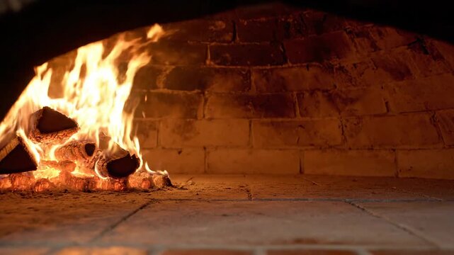 Wood-fired oven interior with burning logs and glowing embers for traditional cooking.