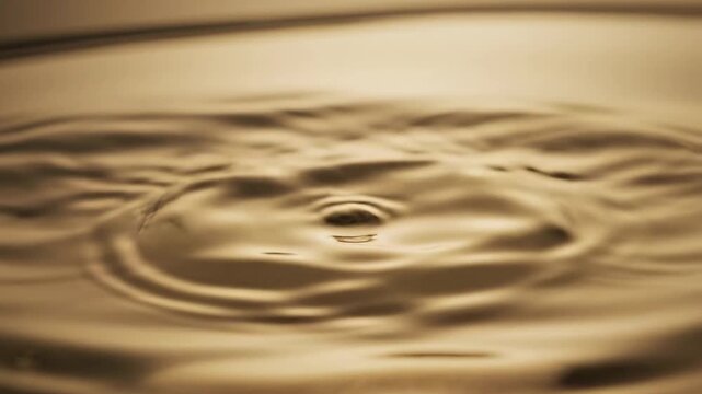 Golden liquid droplet and ripple effect slow motion captivating visuals rich in texture perfect for abstract backgrounds and design elements